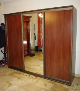 Niska szafa w przedpokoju z drzwiami suwanymi , drzwi wykonane z płyty i lustra srebrnego w okuciach aluminiowych