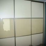 Szafa na wymiar w sypialni, drzwi suwane wykonane z połaczenia płyty laminowanej i szkła lacobel
