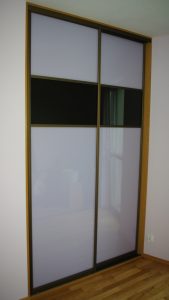Szafa wnękowa z drzwiami suwanymi z obramowanie w kolorze oliwka, na drzwiach połączenie szkła lacobel