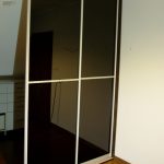 Zabudowa garderoby z drzwiami suwanymi z czarnym szkłem lacoebl