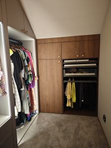 Nowoczesna garderoba na wymiar Kraków z zabudową pod skosami i oświetleniem LED w szafach